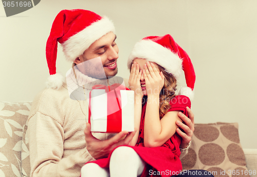 Image of smiling daughter waiting for a present from father