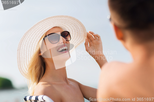 Image of happy couple sunbathing on summer beach