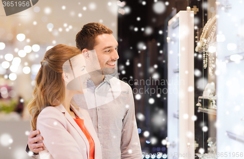 Image of couple looking to shopping window at jewelry store