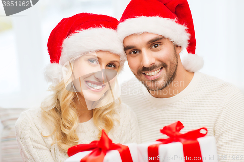 Image of happy couple at home with christmas gift boxes