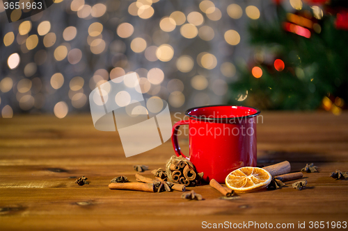 Image of tea cup with winter spices on wooden table