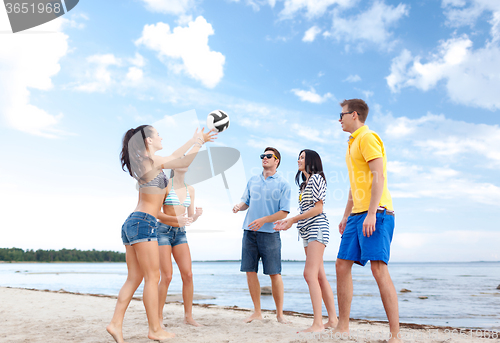 Image of group of happy friends playing beach ball