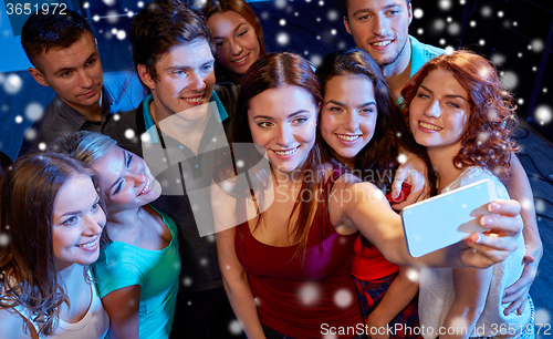 Image of friends with smartphone taking selfie in club