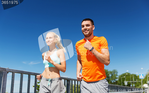 Image of smiling couple running at summer seaside