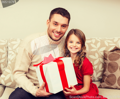 Image of smiling father and daughter holding gift box