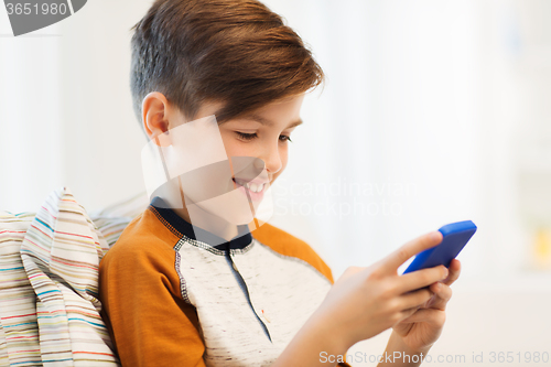 Image of boy with smartphone texting or playing at home