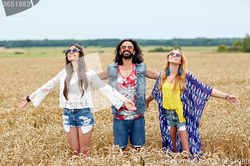 Image of smiling young hippie friends on cereal field