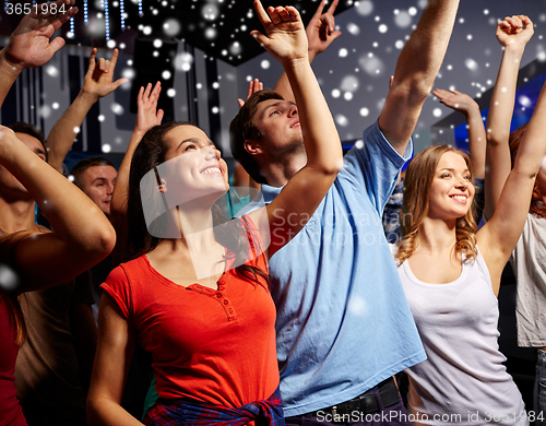 Image of smiling friends at concert in club