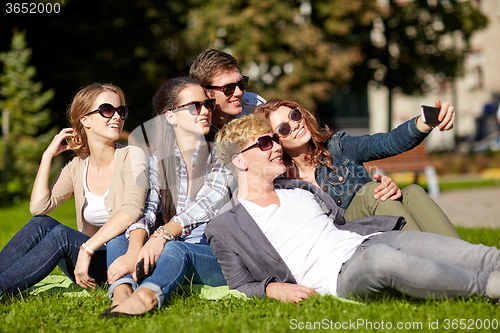 Image of teenagers taking photo outside with smartphone