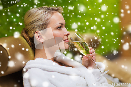 Image of beautiful young woman drinking champagne at spa