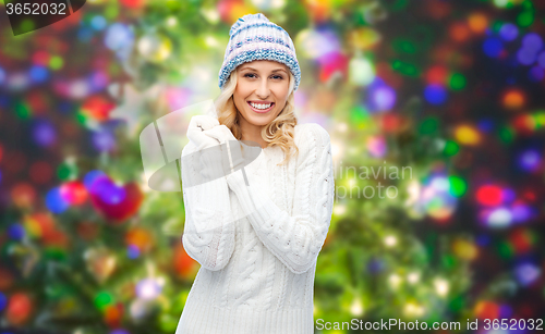 Image of smiling young woman in winter hat and sweater