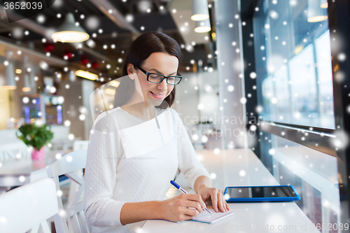 Image of smiling woman with tablet pc at cafe