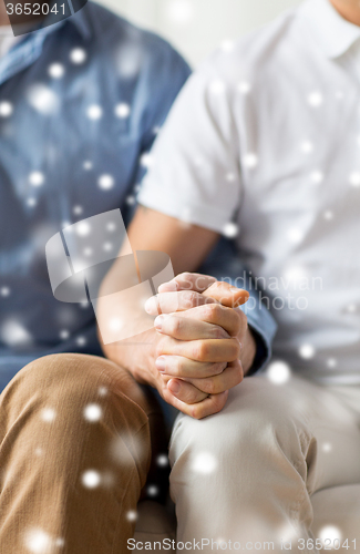 Image of close up of happy male gay couple holding hands