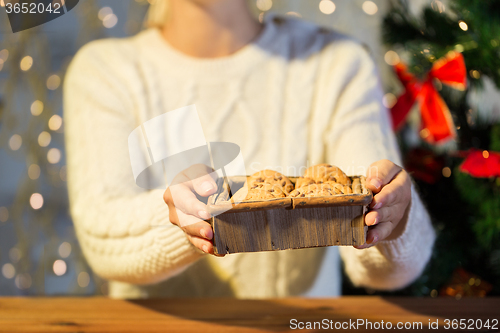 Image of close up of woman with oat cookies at home