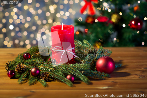 Image of fir branch wreath with candle on wooden table