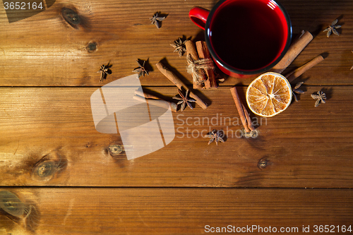 Image of tea cup with winter spices on wooden table