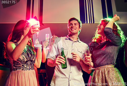 Image of smiling friends with wine glasses and beer in club