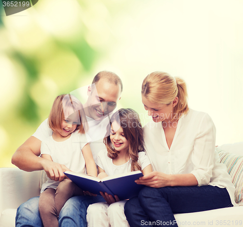 Image of happy family with book at home