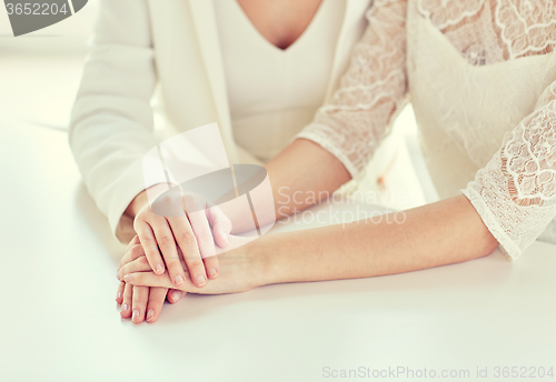 Image of close up of happy married lesbian couple hands