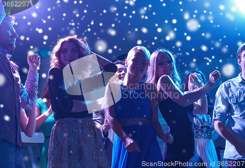 Image of group of happy friends dancing in night club