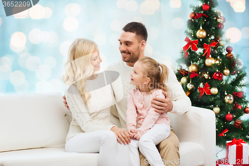 Image of happy family at home with christmas tree