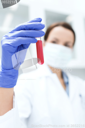 Image of close up of scientist holding test tube in lab