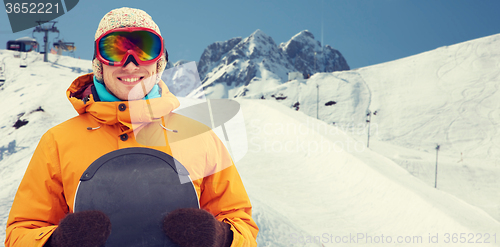 Image of happy young man in ski goggles over mountains