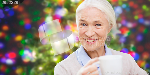 Image of happy senior woman with cup of tea or coffee