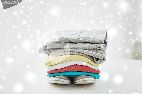 Image of close up of folded shirts and boots on table