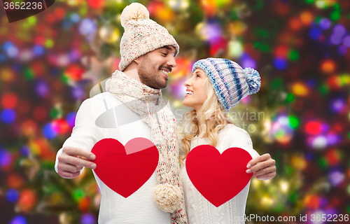 Image of smiling couple in winter clothes with red hearts