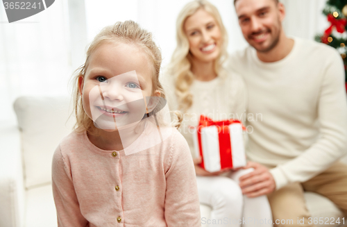 Image of happy family at home with christmas gift box