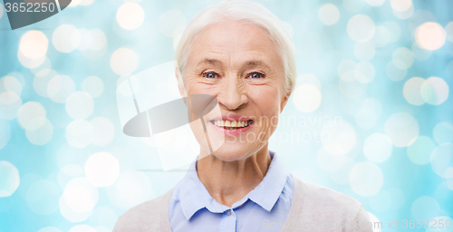 Image of happy senior woman face over blue lights