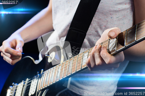 Image of musician playing electric guitar with mediator