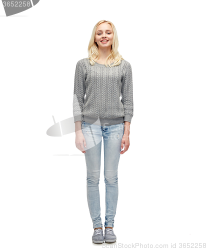 Image of smiling young woman in gray pullover and jeans