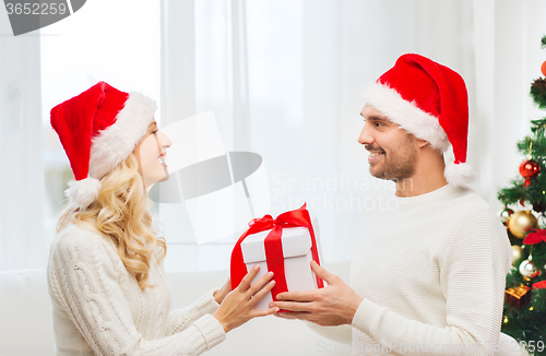 Image of happy couple at home with christmas gift box