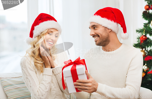 Image of happy couple at home with christmas gift box