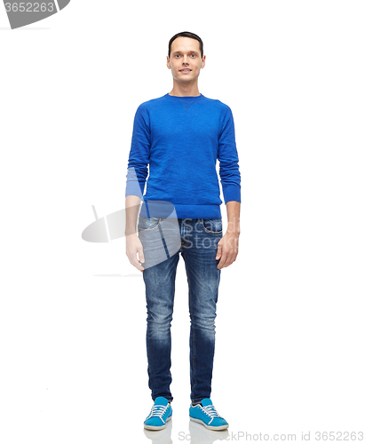 Image of smiling young man in blue pullover and jeans