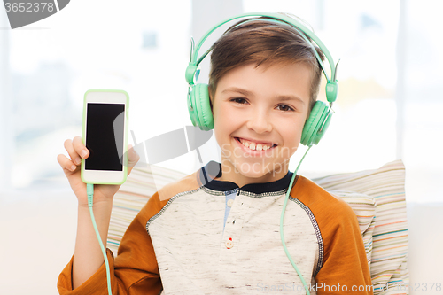 Image of happy boy with smartphone and headphones at home