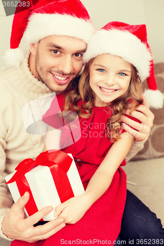 Image of smiling father and daughter holding gift box