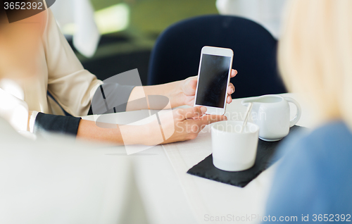 Image of close up of women with smartphone at restaurant