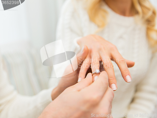 Image of close up of man giving diamond ring to woman