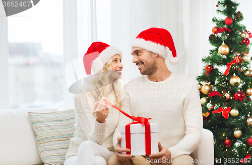 Image of happy couple at home with christmas gift box