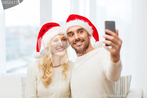 Image of couple taking selfie with smartphone at christmas