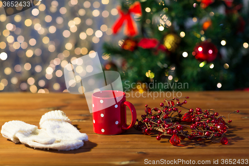 Image of tea cup with mittens and christmas decoration