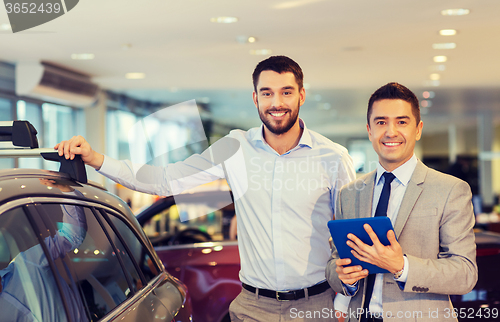 Image of happy man with car dealer in auto show or salon