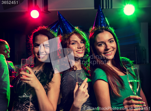 Image of smiling friends with glasses of champagne in club