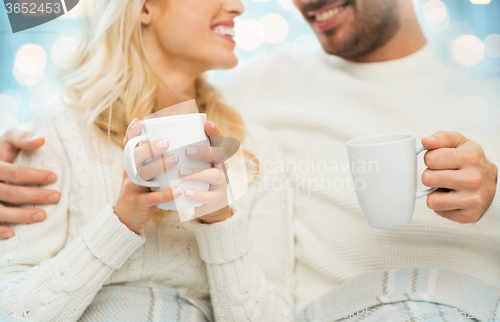 Image of close up of happy couple with tea cups at home