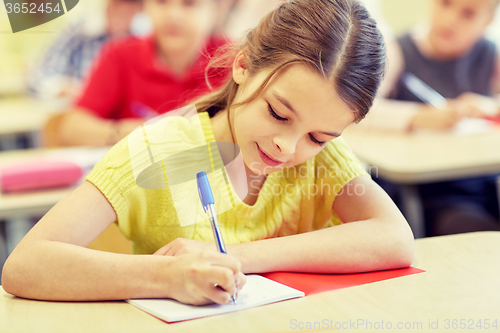 Image of group of school kids writing test in classroom