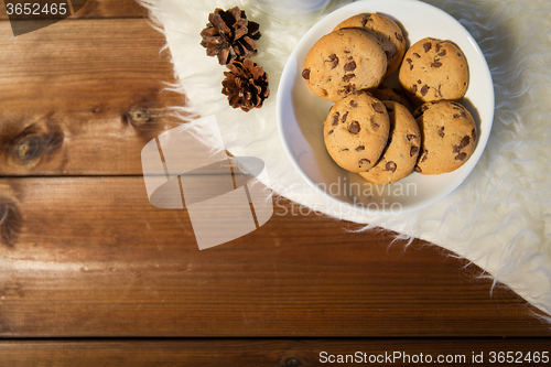 Image of close up of cookies in bowl and cones on fur rug