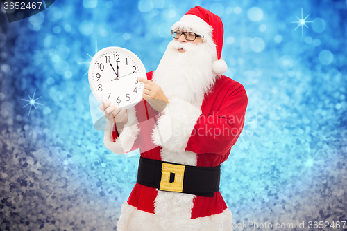 Image of man in costume of santa claus with clock